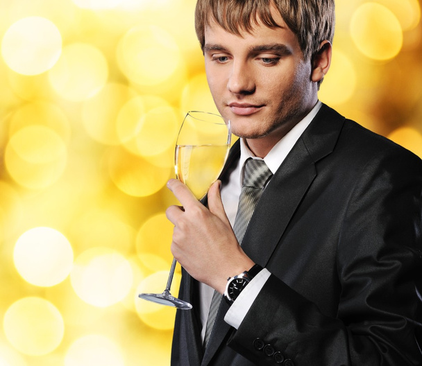 Businessman with a glass of champagne over abstract background - Foto, afbeelding