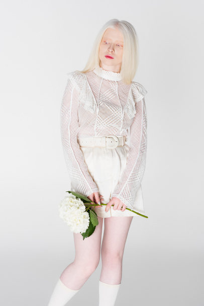 Blonde albino woman holding flower isolated on white - Фото, зображення