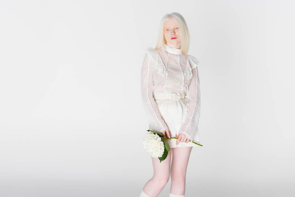 Hübsche Albino-Frau hält Hortensienblüte isoliert auf weiß - Foto, Bild