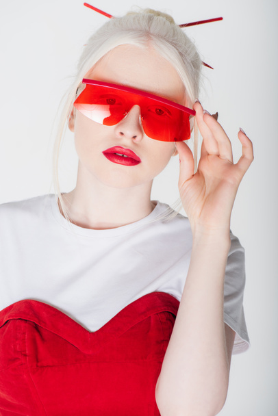 Stylish albino woman holding red sunglasses isolated on white - Photo, Image