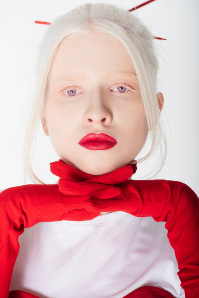 Portrait of albino woman with red lips holding hands in gloves near face isolated on white - Photo, Image