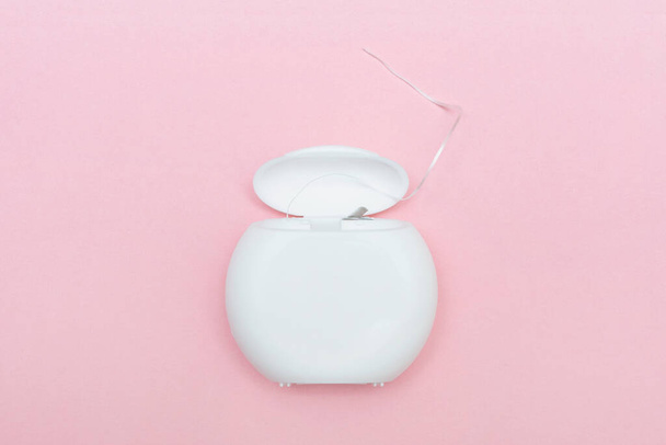 Dental floss on a pink background. Caring for dental health - Photo, Image