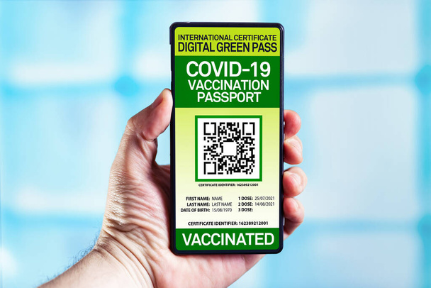 Smartphone ενός τουρίστα που δείχνει ασυλία ψηφιακό διαβατήριο που πιστοποιεί τον εμβολιασμό τους κατά του ιού COVID-19. Ταξιδιώτης δείχνει το διεθνές διαβατήριο υγείας με την πιστοποίηση εμβολιασμού κατά της νόσου coronavirus - Φωτογραφία, εικόνα