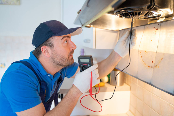 Один ремонтник чинит воздушный фильтр на кухне - Фото, изображение