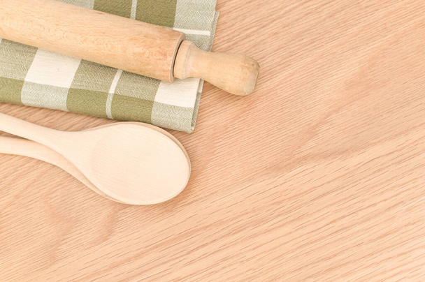 natural wood kitchen utensils and a table napkin on a wooden background with copy space - Photo, Image