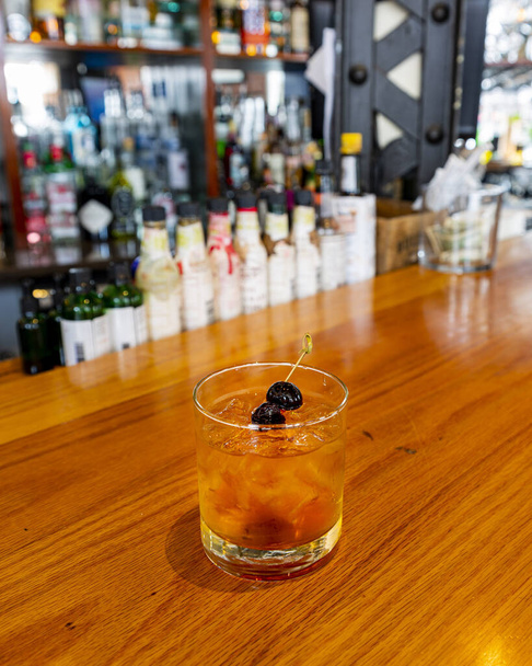 The old fashioned is a traditional old time cocktail featuring brandy cherries rather than cheap cocktail cherries. An enthusiast will appreciate this - Foto, Imagem
