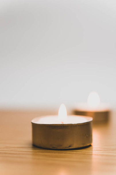 row of white scented wax tea lights on a wooden tabletop with copy space - 写真・画像