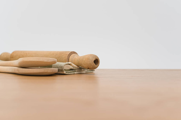 natural wood kitchen utensils and a table napkin on a wooden background with copy space - Valokuva, kuva