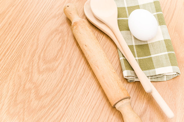 natural wood kitchen utensils and a table napkin on a wooden background with copy space - Photo, Image