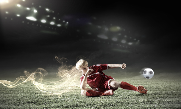 Jugador de fútbol haciendo slide tackle
 - Foto, Imagen