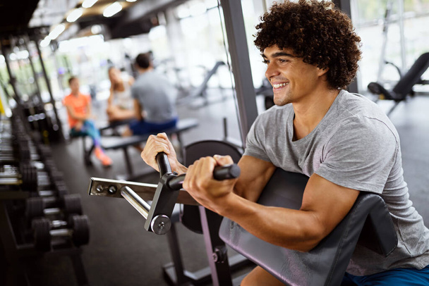 Man working out in gym on fitness machine - Foto, Bild