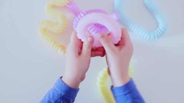 Детские руки играют с антистрессовыми поп-игрушками. - Кадры, видео