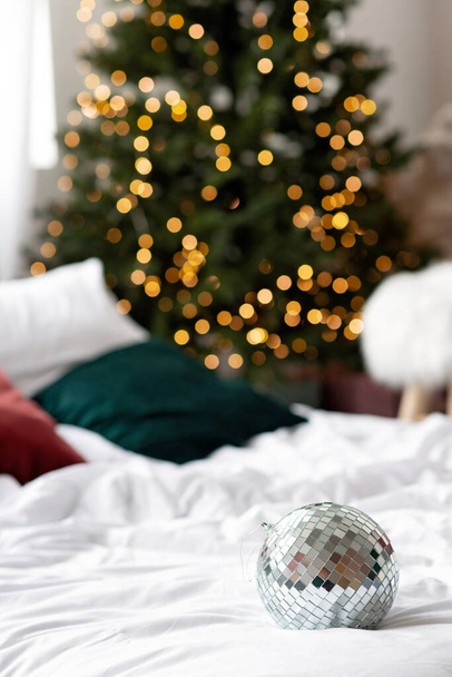 New year background. Mirror ball against the background of bokeh lights of the Christmas tree. Soft selective focus. - Photo, Image