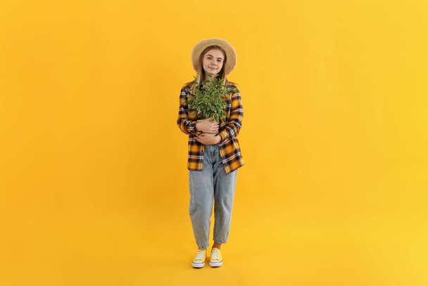 Nuori houkutteleva tyttö puutarhuri keltaisella taustalla - Valokuva, kuva