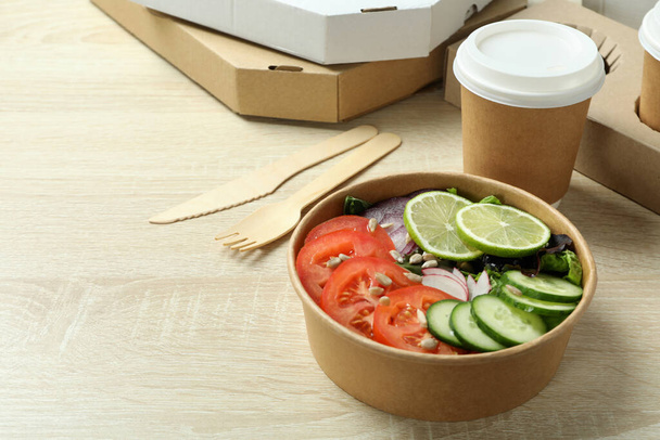 Concept of food delivery with vegetable salad on wooden background - Foto, immagini