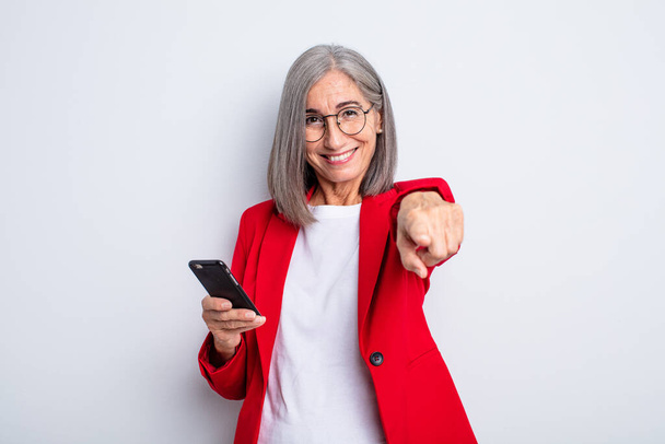 senior pretty woman pointing at camera choosing you.. business and phone concept - 写真・画像