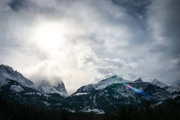 intense mood mountain range in switzerland alps, strong clouds and bright light at midday - Photo, Image