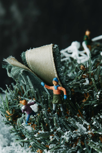 primer plano de algunas personas en miniatura jugando con un poco de nieve falsa - Foto, imagen