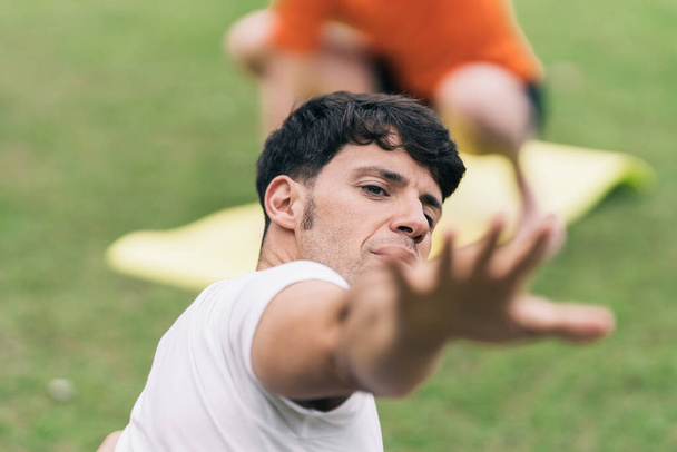 Concentrati sul viso di un uomo che si allunga mentre fa yoga all'aperto - Foto, immagini