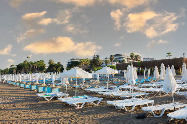 Tenger, strand, esernyők és napozóágyak a Side Antalya.cloudy ég. Szelektív fókusz. Nincsenek emberek. naplemente ég - Fotó, kép