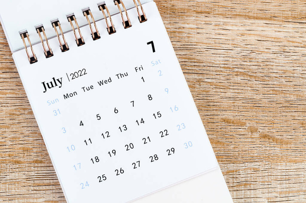 July 2022 desk calendar on wooden table. - Фото, зображення