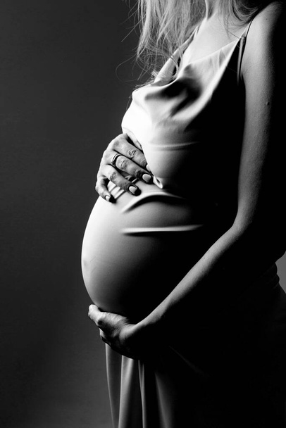 caucasian pregnant woman stroking her belly on white background. Copy space. The concept of healthy digestion, lifestyle, IVF - Foto, imagen