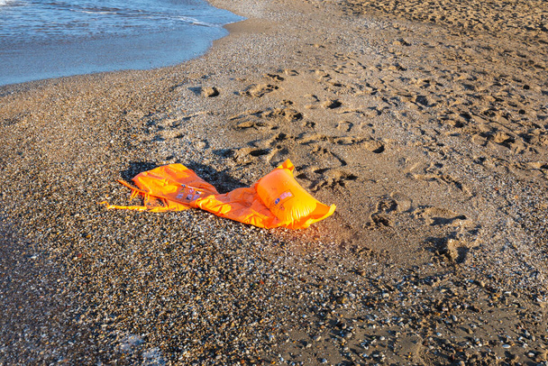 Muovi lelu puhallettava liivi unohdettu rannalla. Valikoiva fokus - Valokuva, kuva