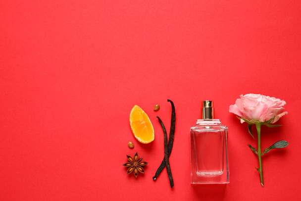 Flat lay composition with bottle of perfume and fresh citrus fruit on red background. Space for text - Foto, Imagem