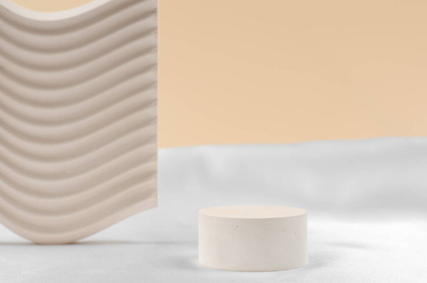 Plaster podium for the presentation of cosmetic products. Empty beige podium on white and beige background with geometric shapes. - Foto, Imagen