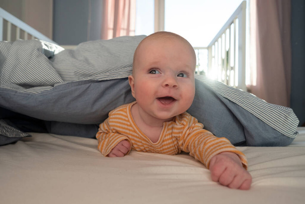 面白いですcaucasian赤ちゃんベッドの上に横たわる. - 写真・画像