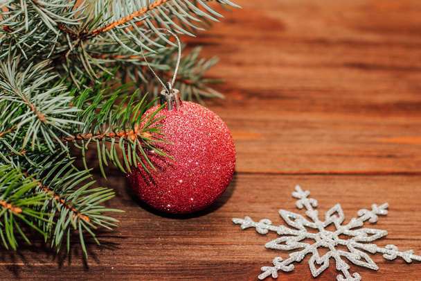 Christmas background with fir sprig and red toys on wooden boards. - Foto, Bild
