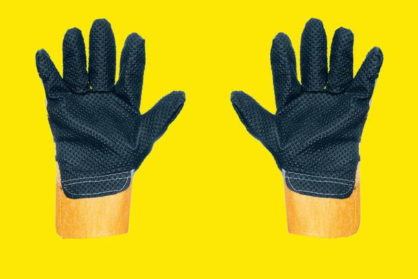 Δύο γάντια κατασκευής με δάχτυλα. Προστατευτική ενδυμασία για εργασία και κατασκευή. φόντο. - Φωτογραφία, εικόνα