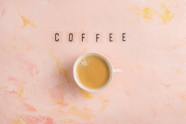 Cup of espresso coffee and text COFFEE on pink background - 写真・画像