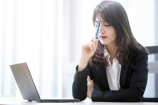 Стресс бизнес работает красивая азиатская женщина думает с ноутбуком в современном офисе - Фото, изображение
