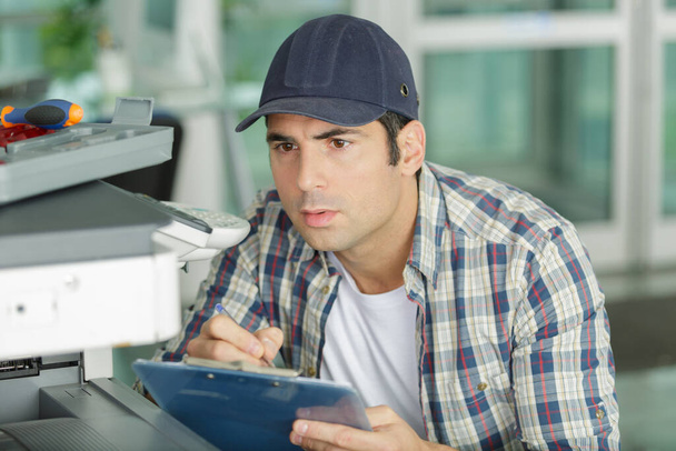 man technician repairing a printer - Foto, Imagen