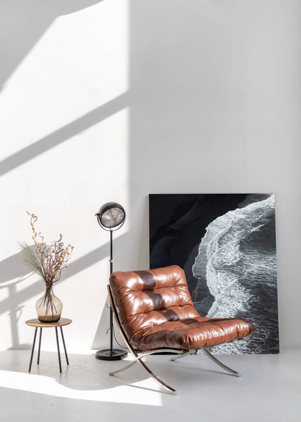 Мінімалістичний і сучасний дизайн інтер'єру з кріслом біля білої стіни. Абстрактний живопис. Концепція домашнього декору. Світла кімната зі зручними меблями
 - Фото, зображення