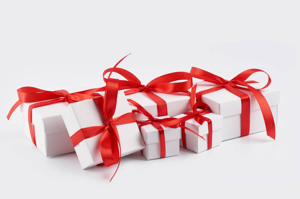 White gift box with red ribbon bow, isolated on white. White box with red ribbon. Gift for Christmas, New Year, Birthday, Valentine's Day.  - Fotoğraf, Görsel