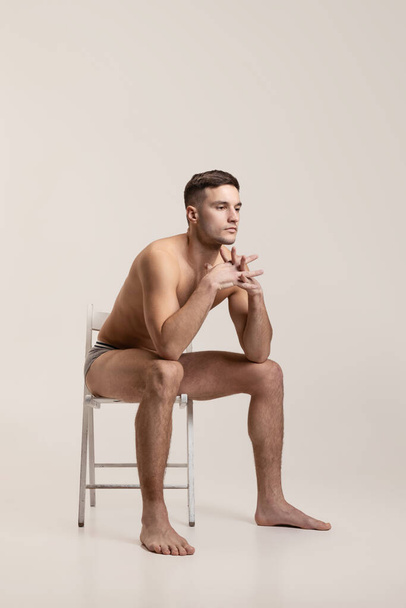 Portrait of young sad handsome shirtless man isolated on gray studio background. Natural beauty - Foto, Imagem
