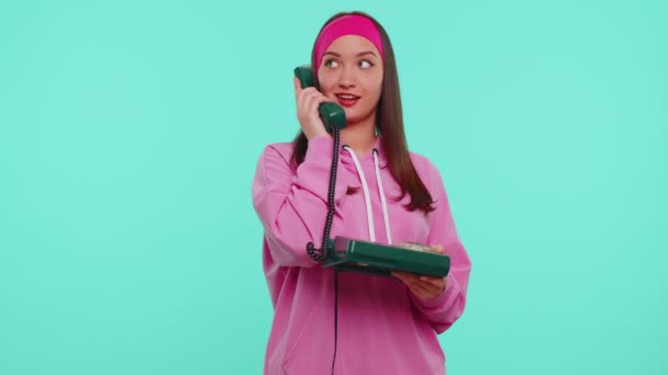 Cheerful teen girl secretary talking on wired vintage telephone of 80s, says hey you call me back - Footage, Video