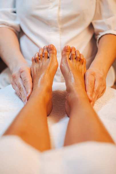 Hands masseuse massaging womans foot in spa salon. Healthy lifestyle. Spa body care. - Photo, Image
