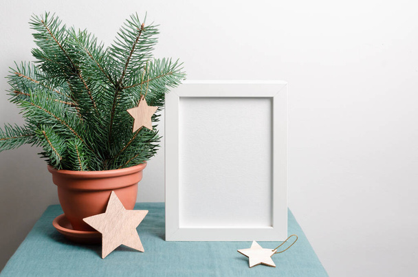 Christmas frame mockup with fir tree branches in terracotta pot an wooden stars decorations - Фото, зображення