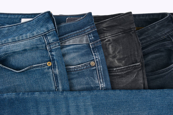 Beyaz arka planda kot pantolon desenli mavi kot pantolonların çeşitli tonlarında. Tasarım için Denim arkaplan dokusu. Kumaş kumaş. Arkaplan olarak kullanılabilen mavi kot. - Fotoğraf, Görsel
