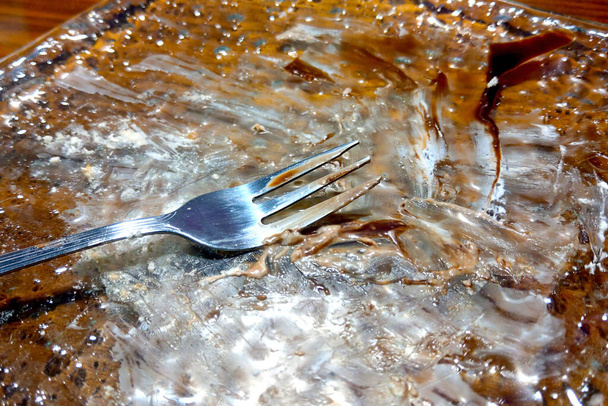 A dirty plate with a fork after eating, dessert - Photo, Image