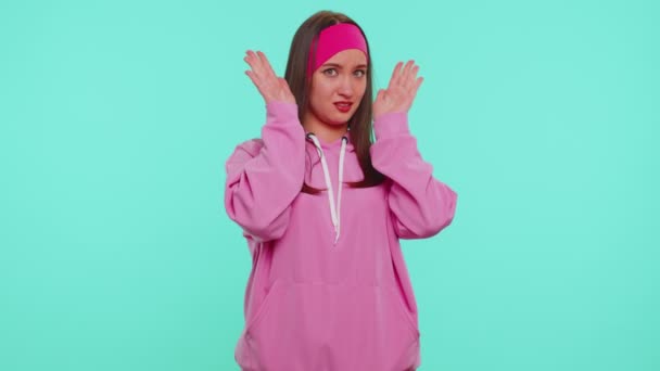 Studentin im rosafarbenen Kapuzenpulli schließt Augen und zeigt Stopp-Geste, verwirrt, scheu, verängstigt - Filmmaterial, Video