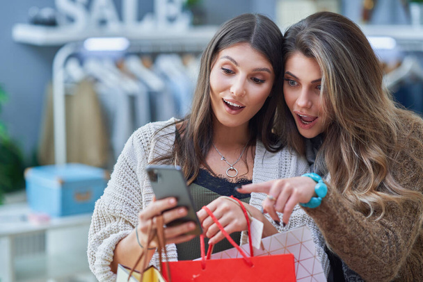 Группа счастливых друзей во время шопинга по телефону - Фото, изображение