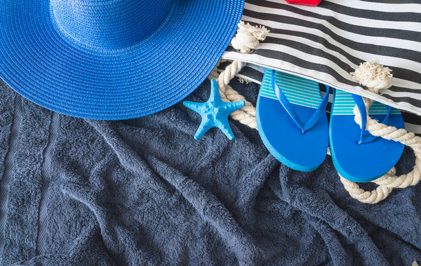 Концепция летнего пляжного отдыха; Голубая шляпа, пляжная сумка, флип-флоп и морские звезды - Фото, изображение