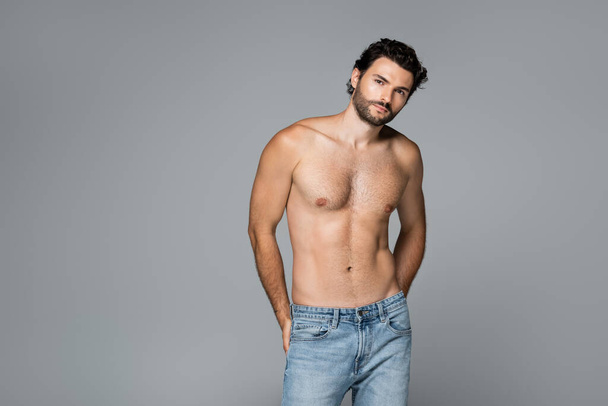 good-looking and shirtless man in jeans looking at camera isolated on grey - Photo, Image