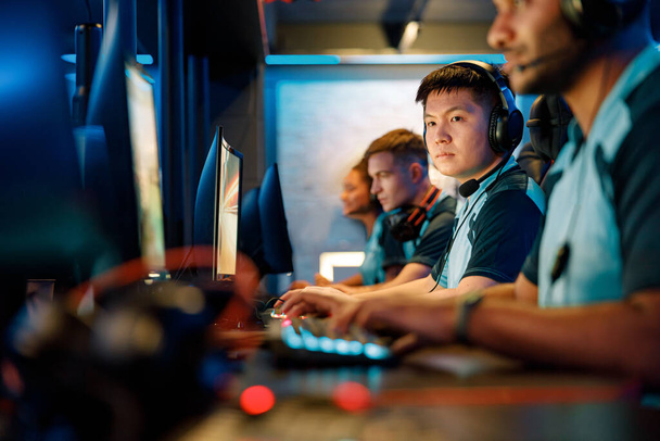 Молодые геймеры играют в онлайн-игры в кибер-клубе - Фото, изображение