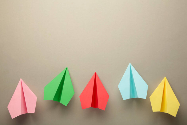 Color paper plane on grey background, Business competition concept. Top view - Fotoğraf, Görsel