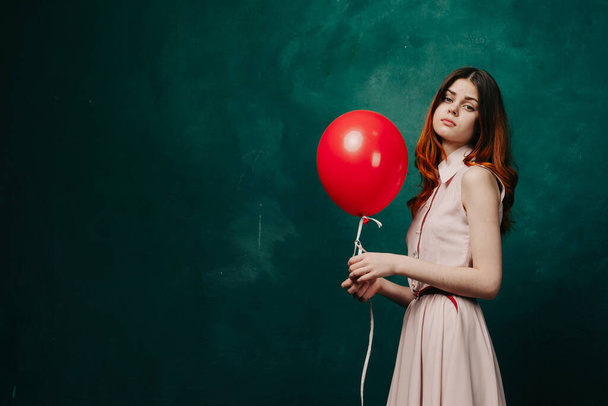 pretty woman in dress red balloon birthday green background - Photo, Image
